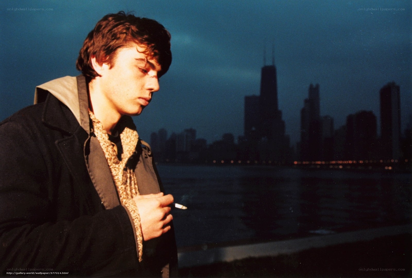 man smoking by city skyline