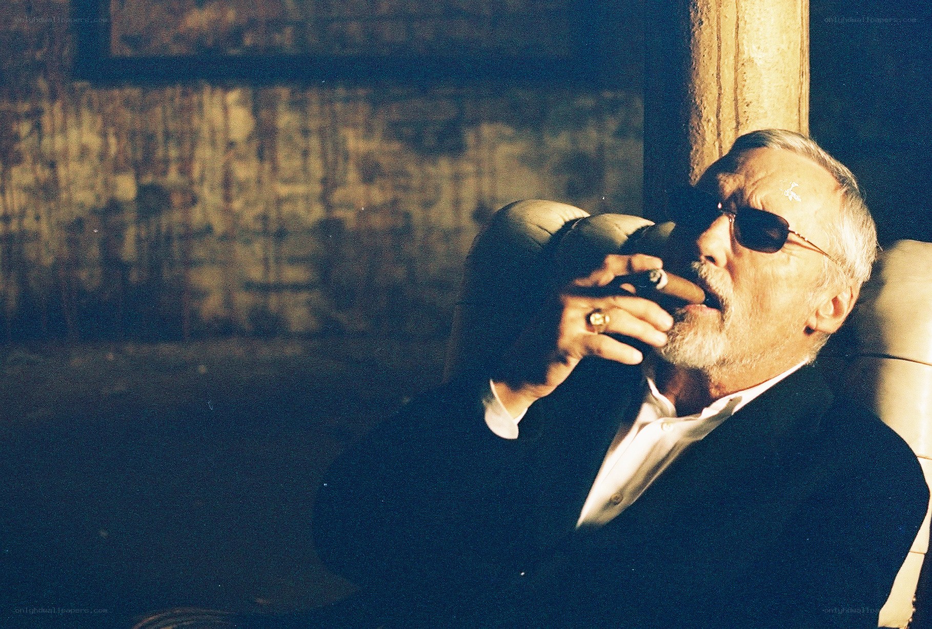 man smoking cigar in dim light
