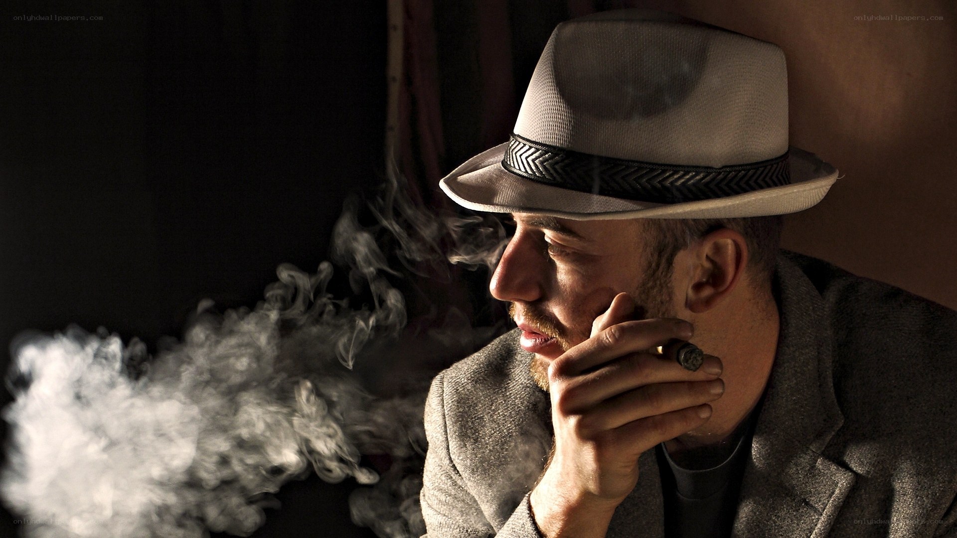 man smoking cigar in hat