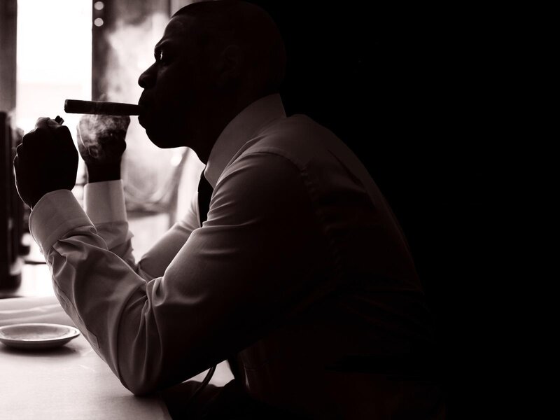 man smoking cigar in silhouette