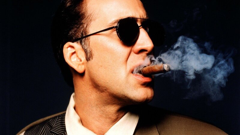 man smoking cigar in sunglasses