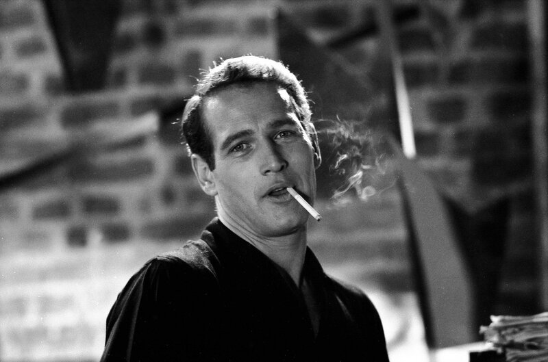 man smoking cigarette in black and white