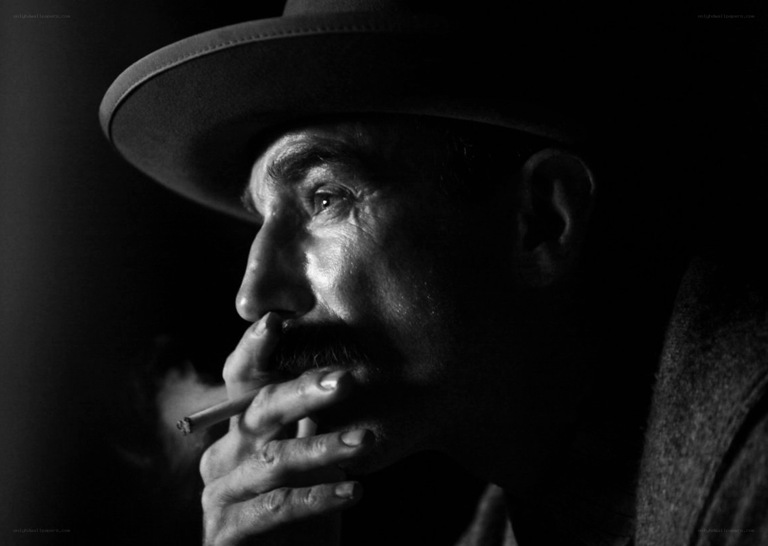 man smoking cigarette in hat
