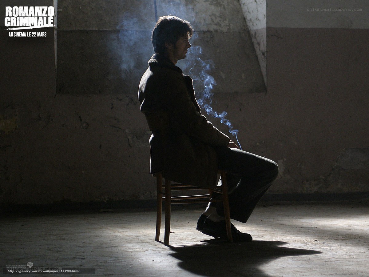 man smoking in dim room