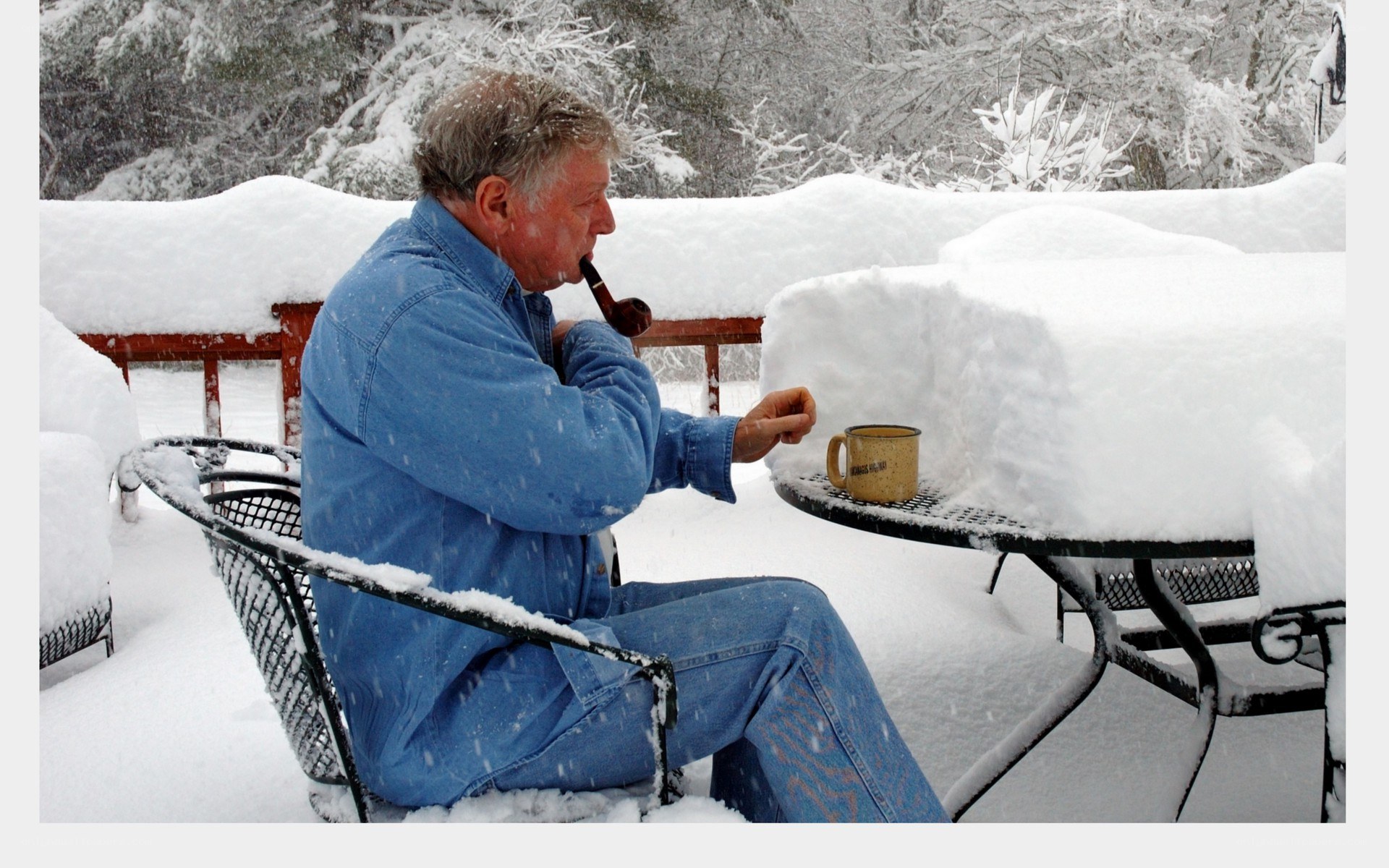 man smoking pipe in snow