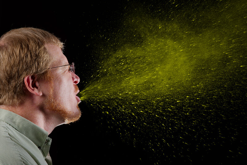 man sneezing with particles