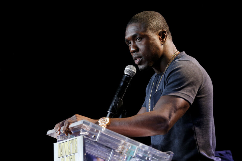 Man Speaking at Podium — Black, Serious