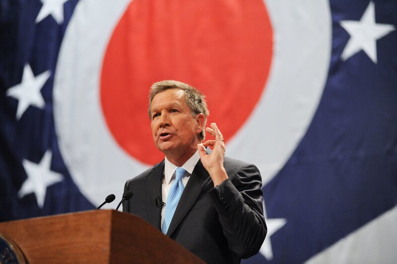 Man Speaking at Podium — Blue, Formal, Photograph, Flag