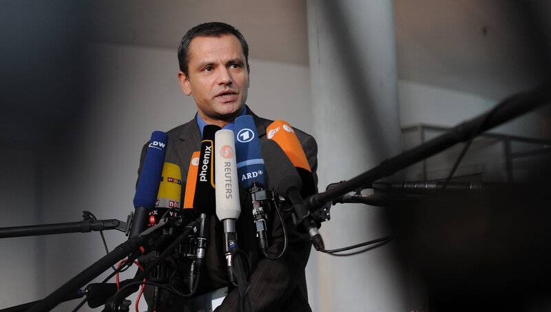 man speaking at press conference