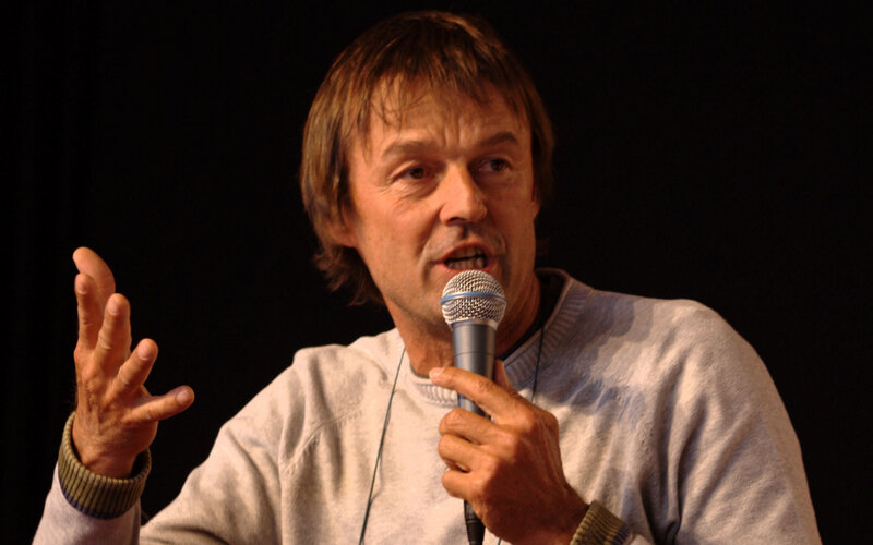 Man Speaking into Microphone — Black, Engaged, Photograph, Sweater