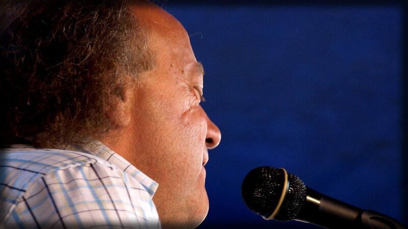 Man Speaking into Microphone — Blue, Serious