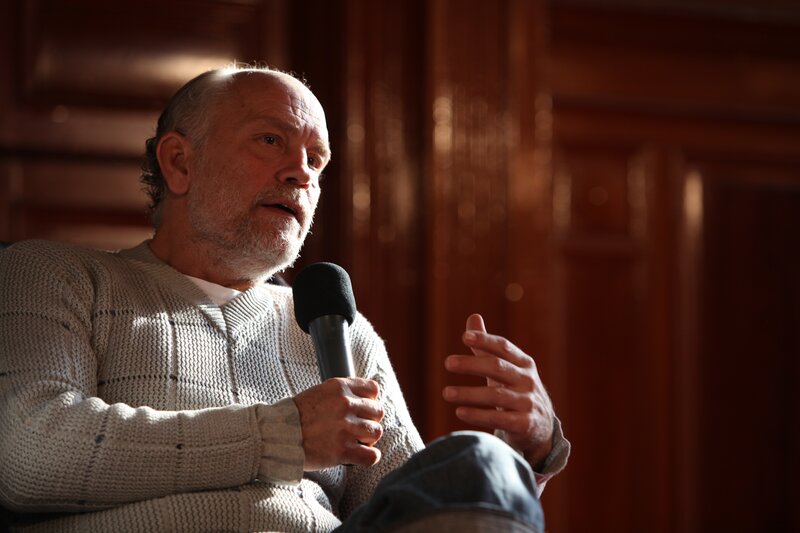 Man Speaking into Microphone — Brown, Dramatic