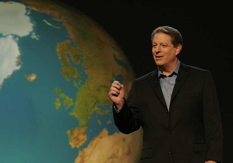 Man speaking on stage with globe