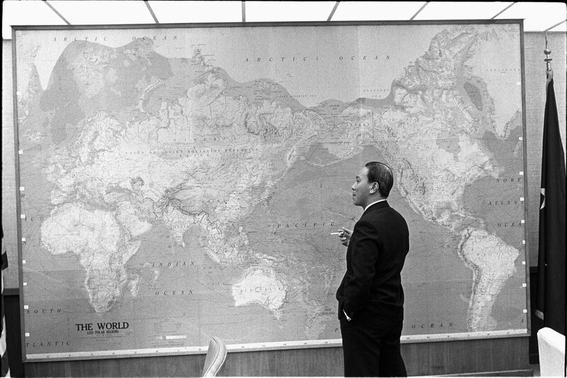 Man standing before world map