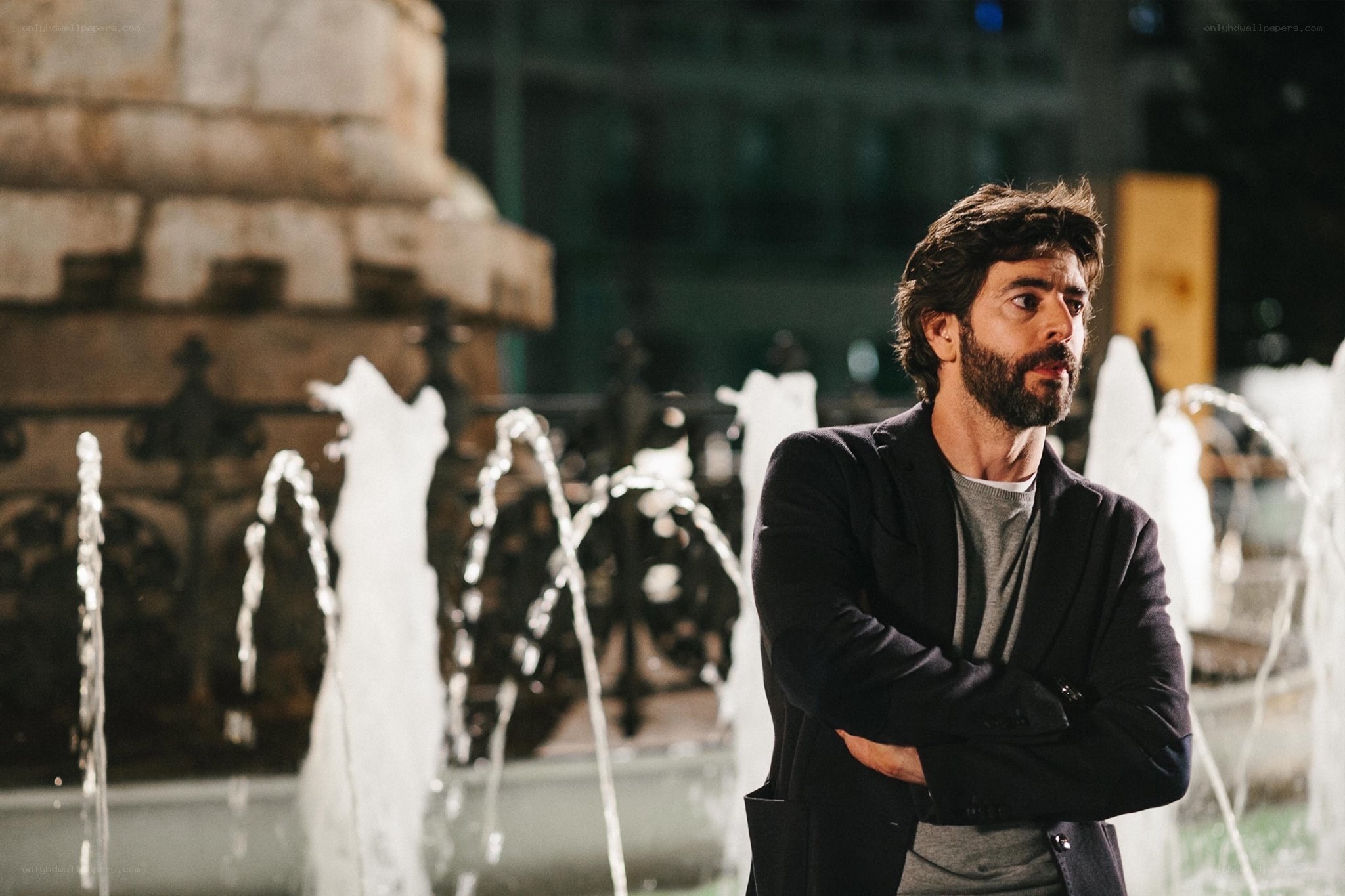Man standing by fountain at night