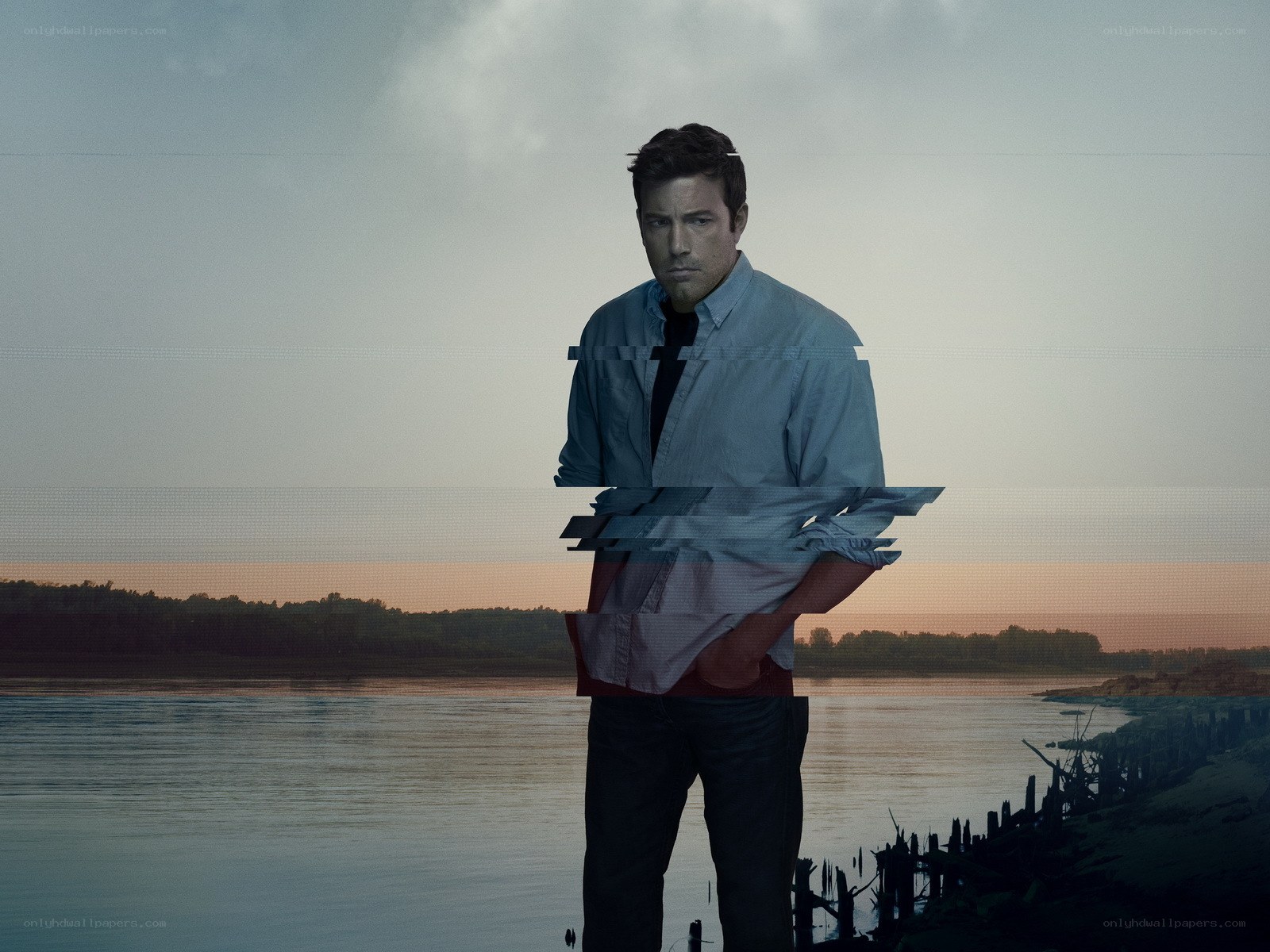 man standing by river at dusk
