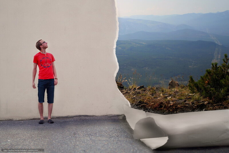 Man standing by torn paper wall