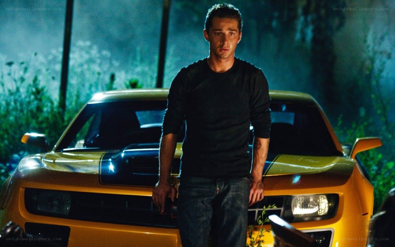 man standing by yellow car