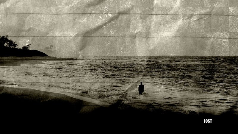 man standing in ocean at dusk