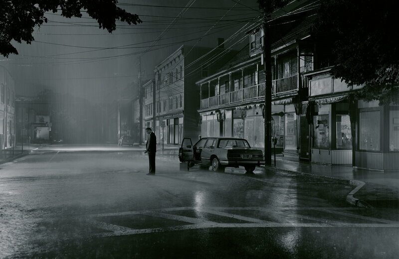 Man standing in rain on street