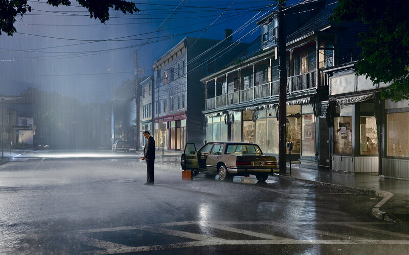 man standing in rain on street