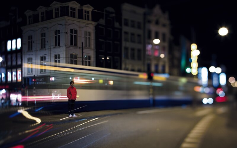 Man standing on a city street at night