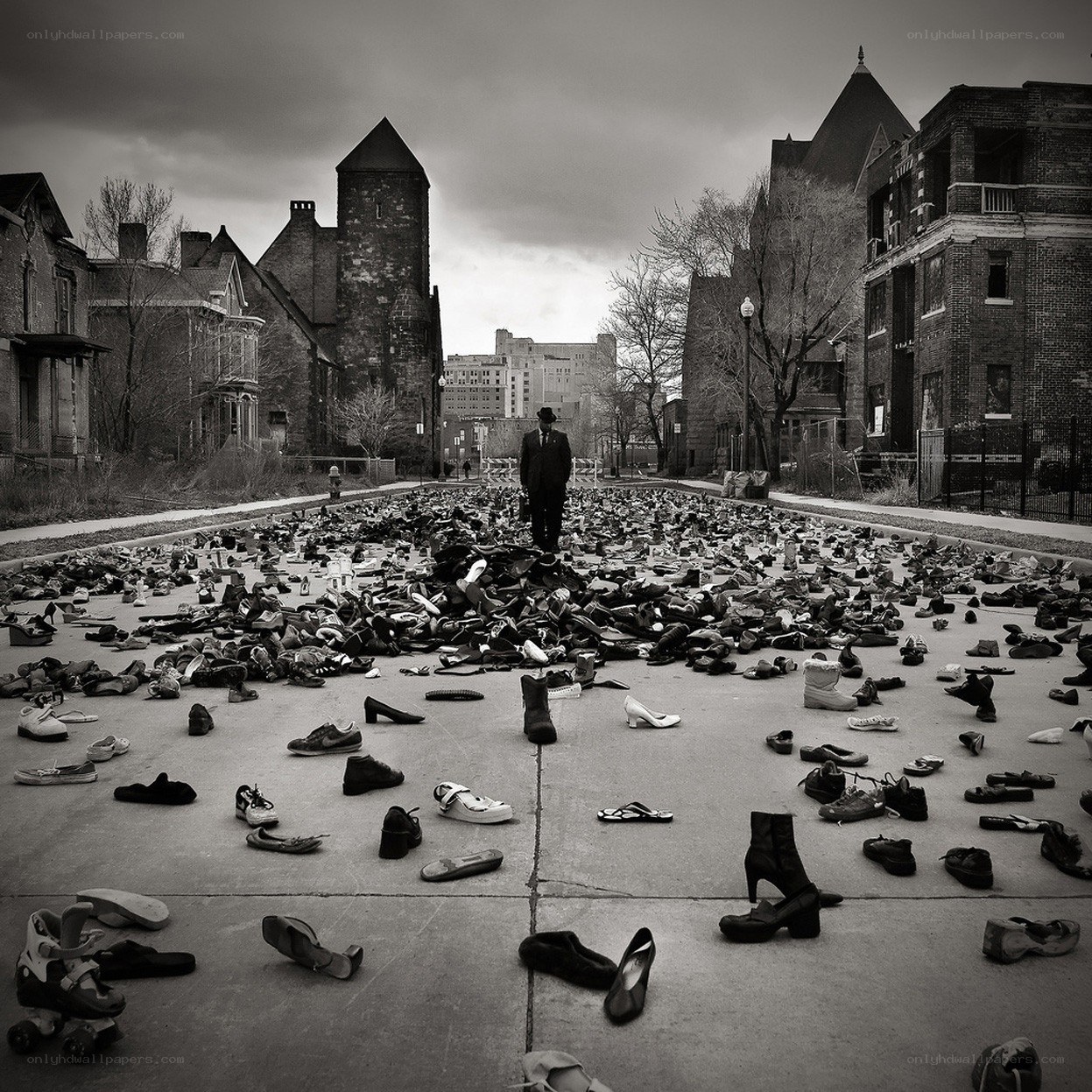 Man stands amidst scattered shoes