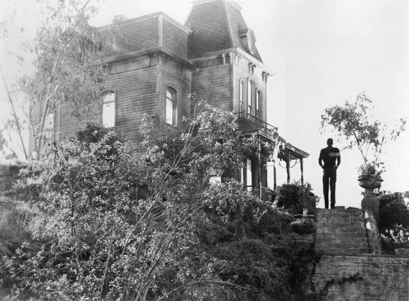 Man stands before a large house