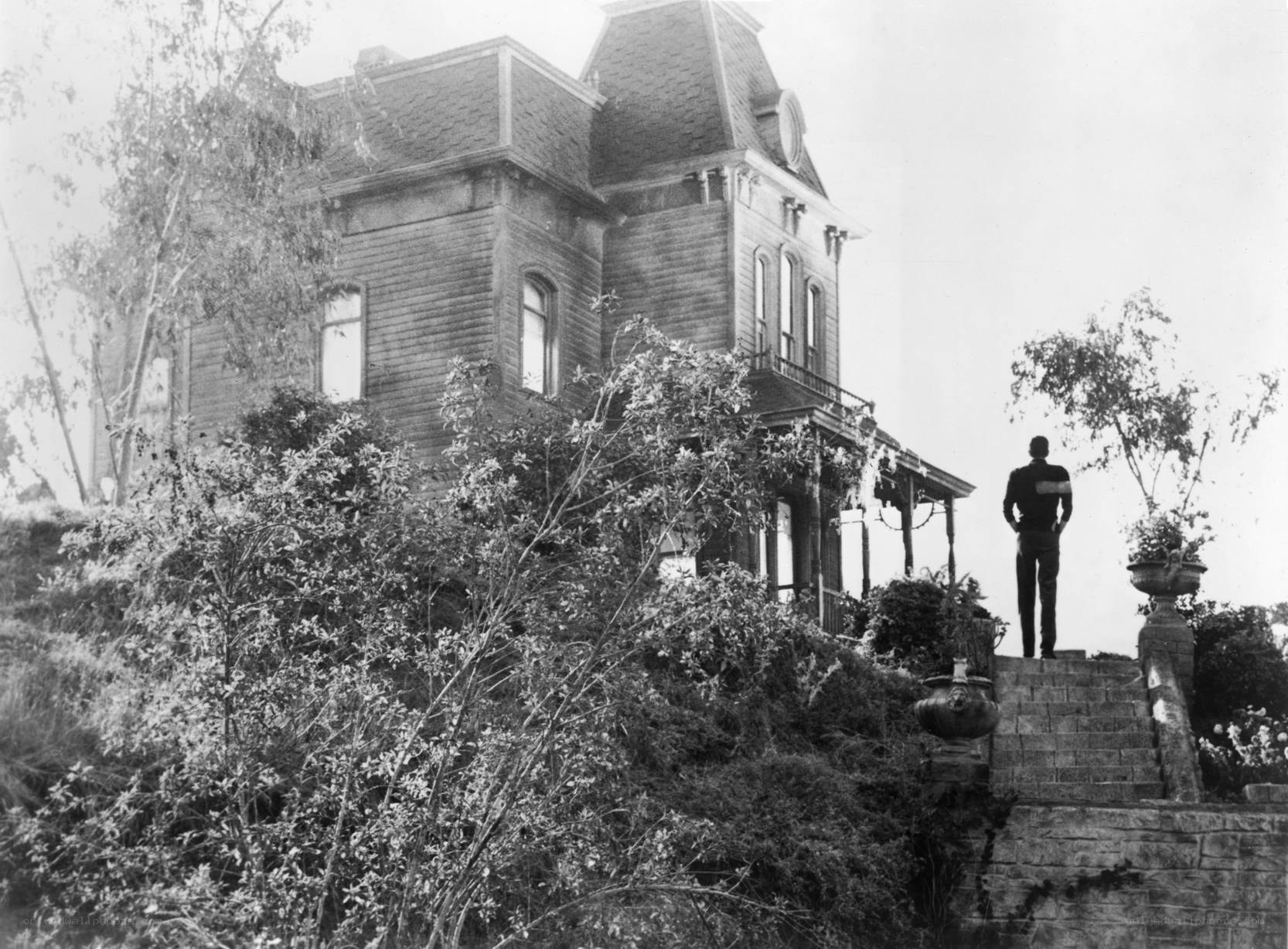 Man stands before a large house