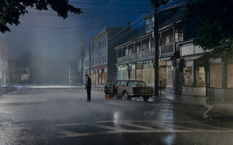 Man stands in rain on empty street