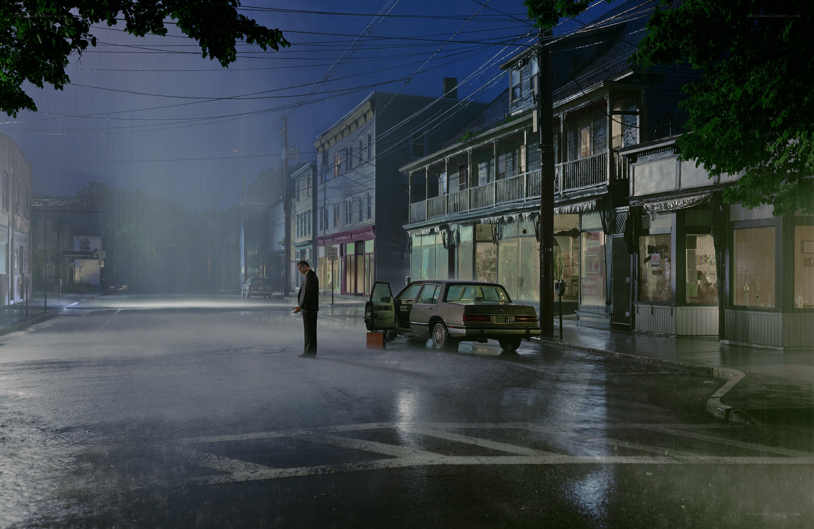 Man stands in rain on empty street