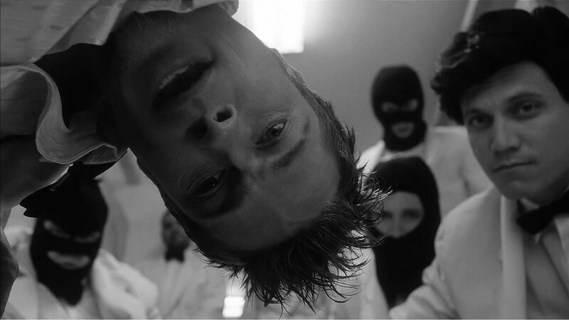 man surrounded by masked figures