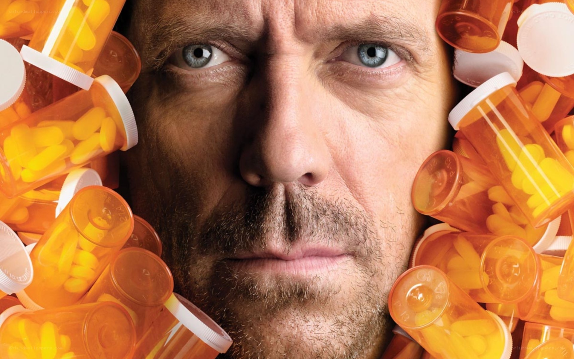 man surrounded by pill bottles