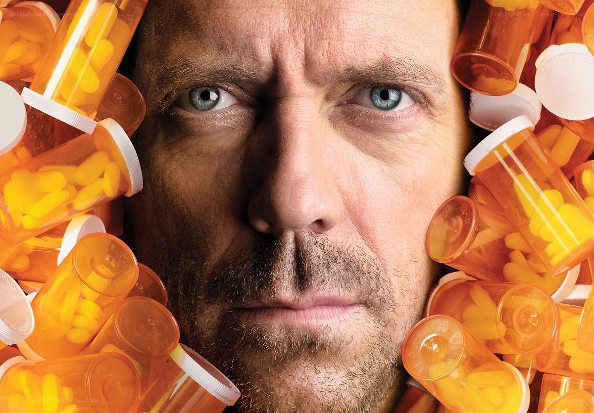man surrounded by pill bottles