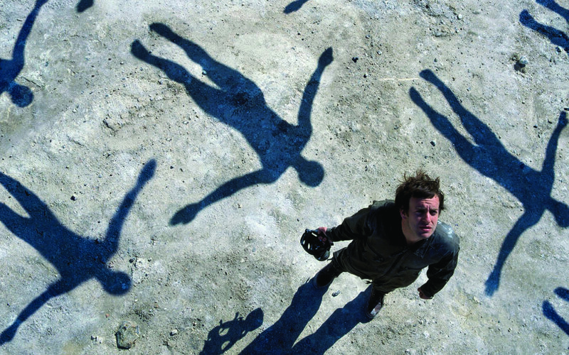 Man surrounded by shadow figures
