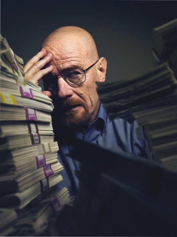 man surrounded by stacks of money