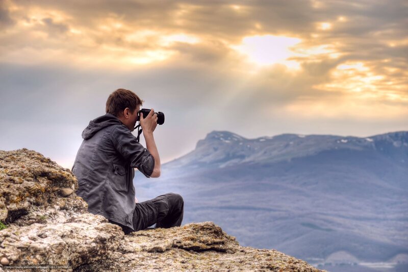 Man Taking Photo on Cliff