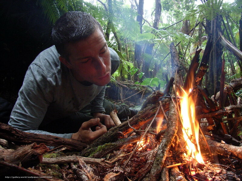 man tending a fire in the forest