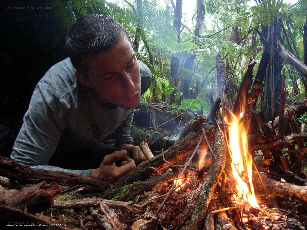 man tending a fire in the forest