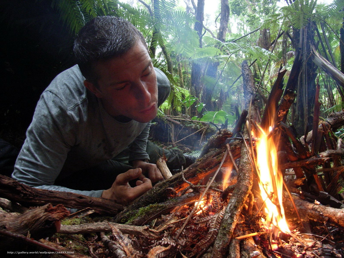 man tending a fire in the forest