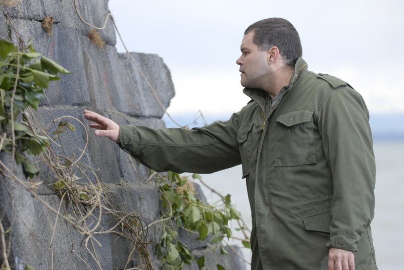 man touching stone wall