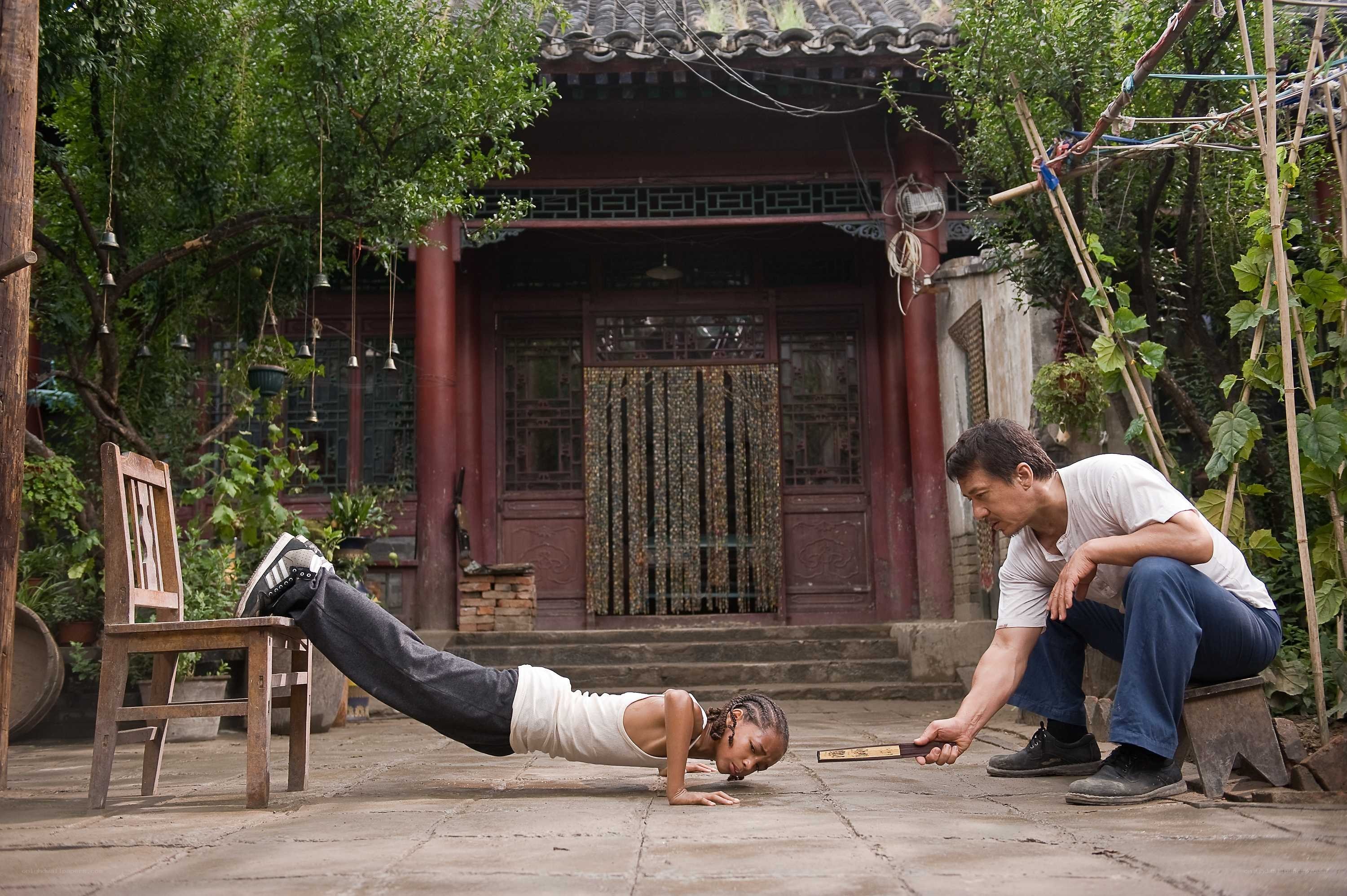 Man training child in courtyard