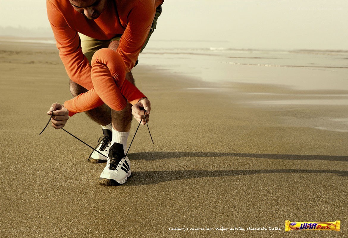 man tying shoes on beach