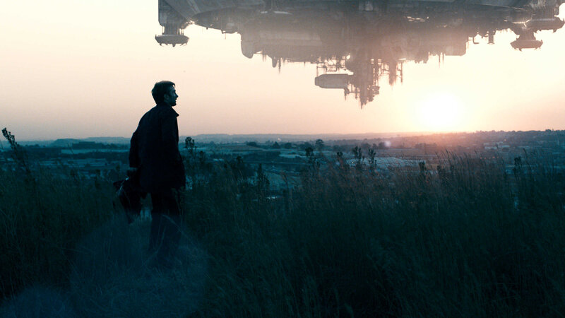 man under alien ship at sunset