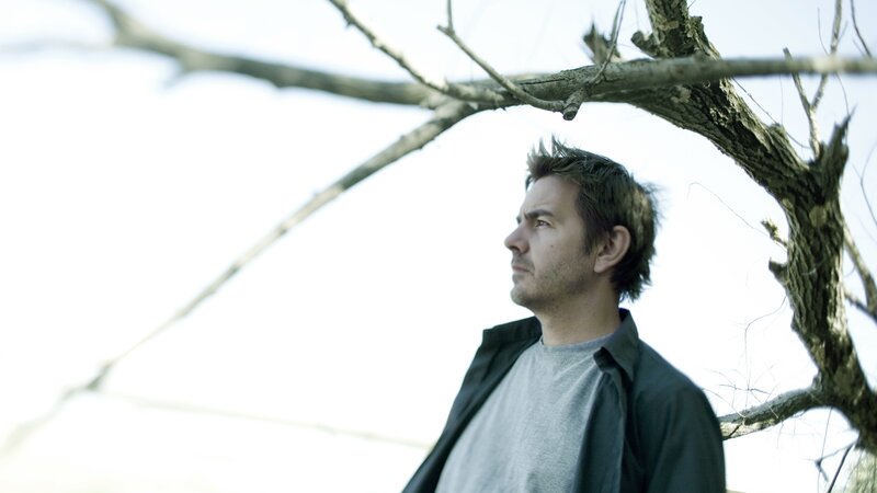 man under bare tree