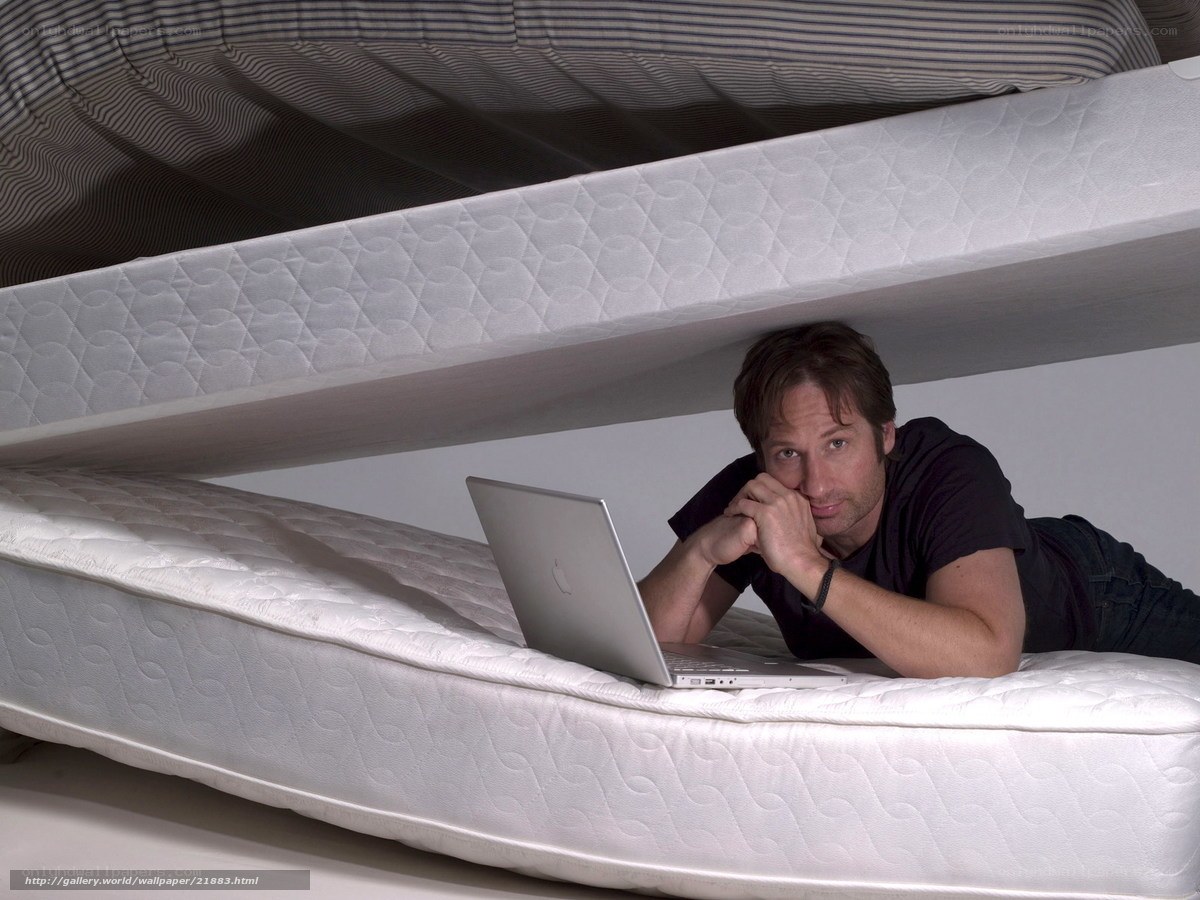 man under mattress with laptop