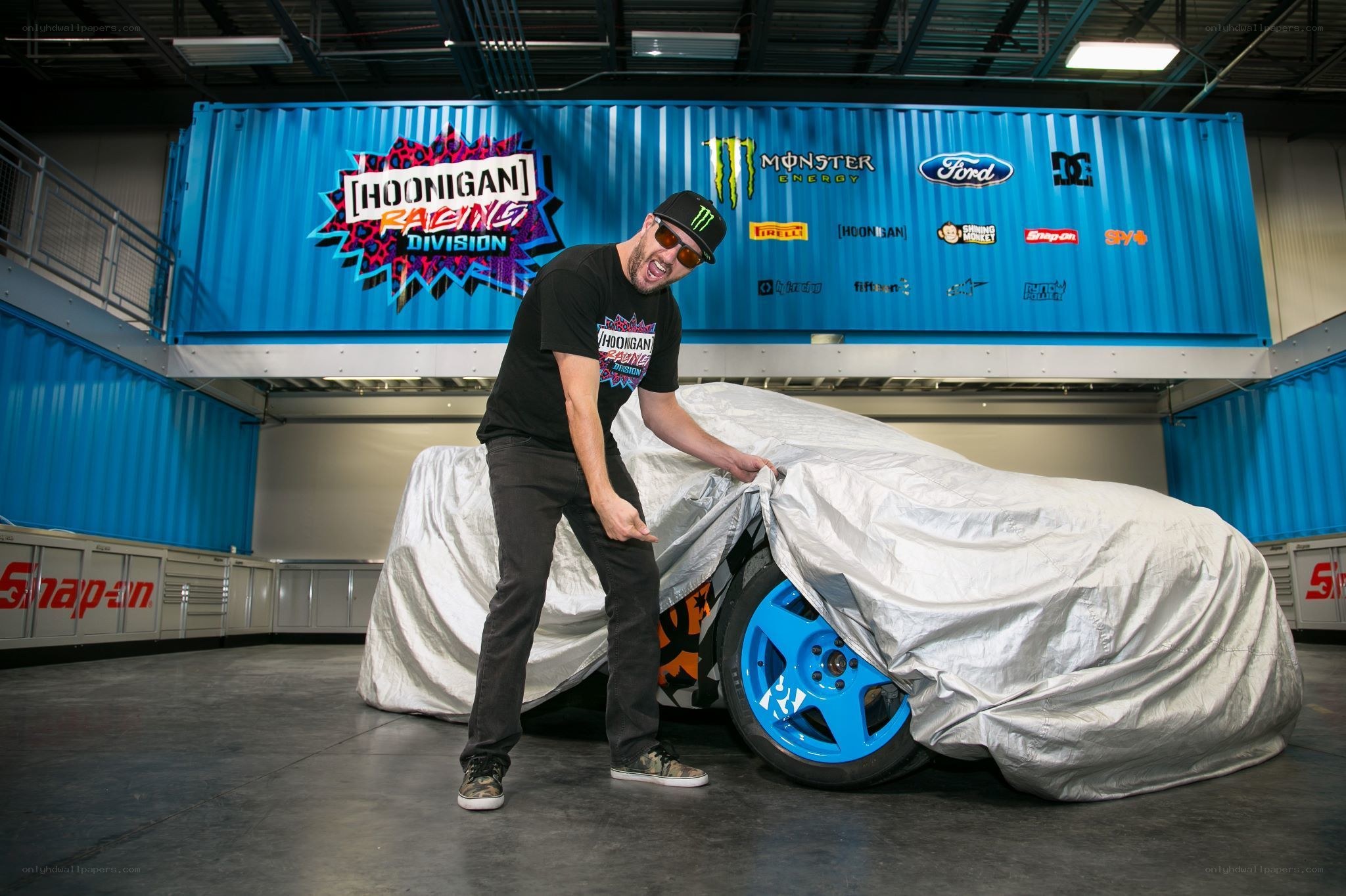 Man unveiling a covered car