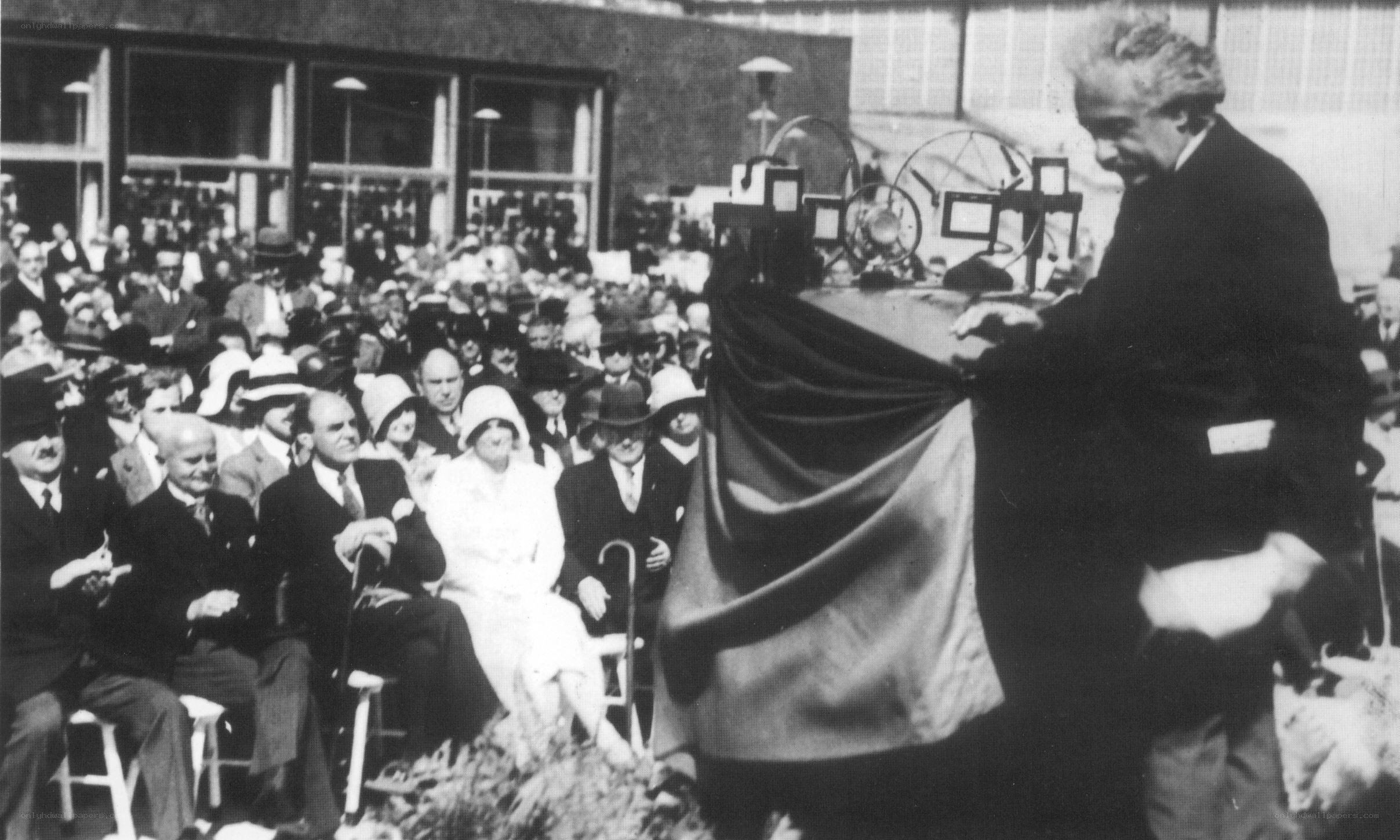 Man unveiling a machine to crowd