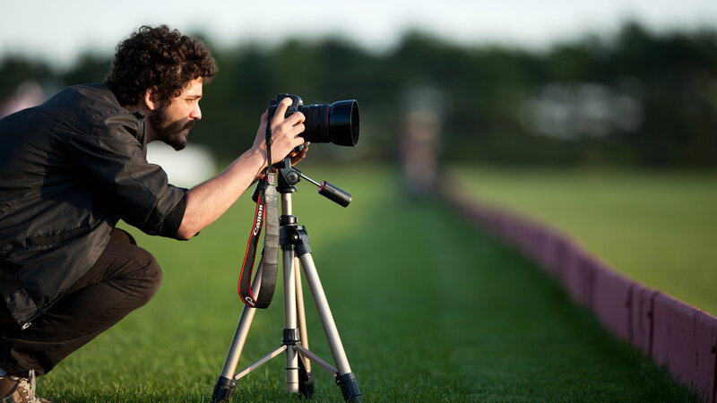 Man Using Camera on Tripod