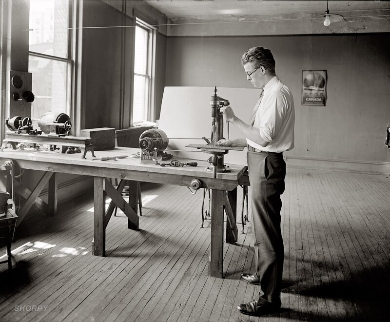Man using drill press in workshop